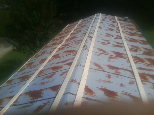 Rusted metal roof panels with new wood purlins before replacement — Storm Damage Roof Repair in Olivet by Roofing Brothers