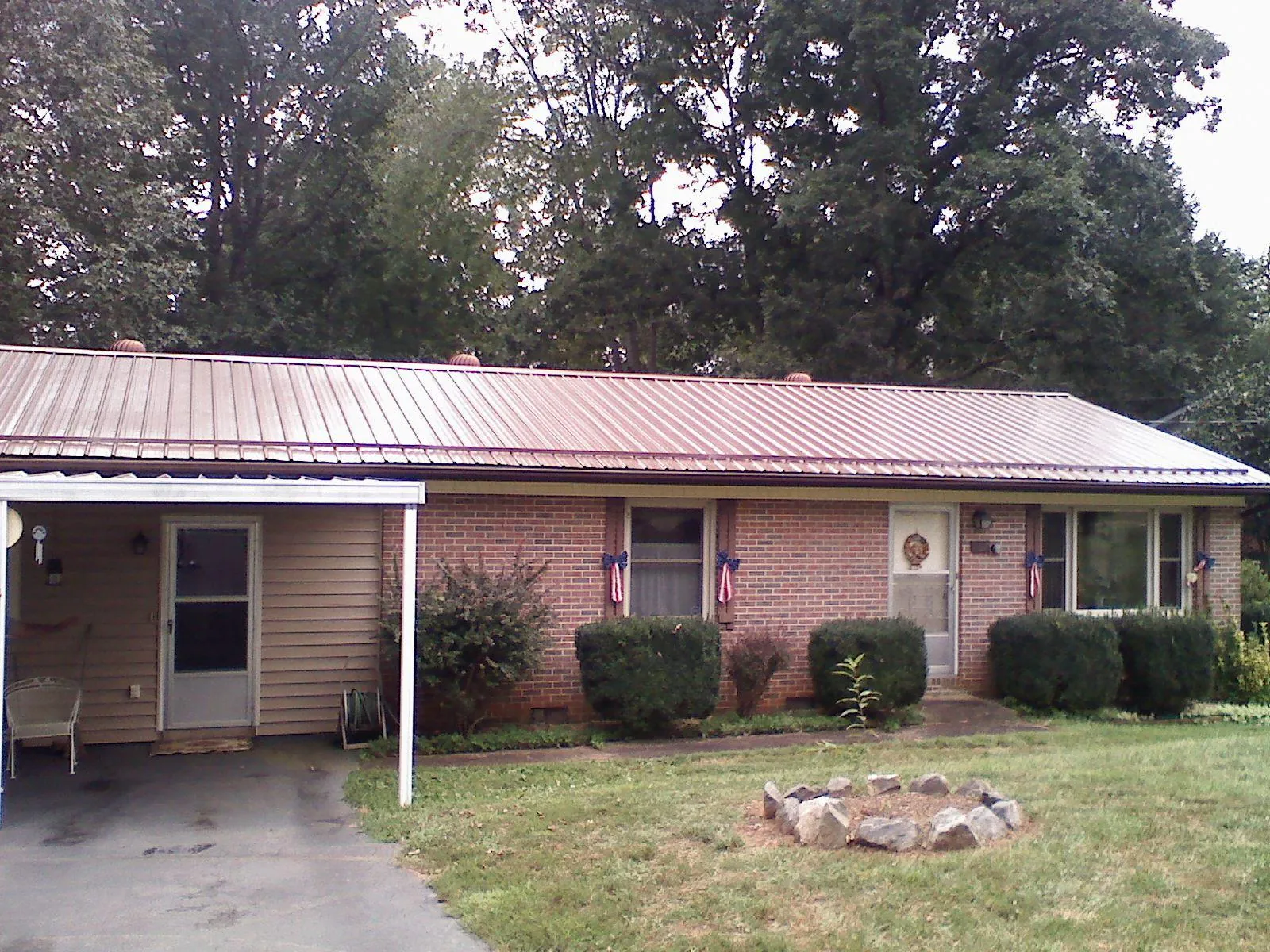 Bronze metal roof and carport on a brick ranch home — Roof Repair work by our crew in Olivet